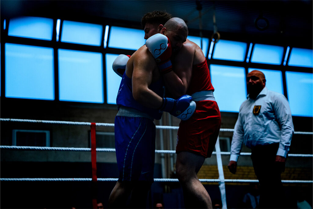 Eventfotografie eines Boxkampfs. Boxer im Clinch