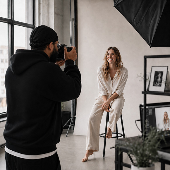Fotograf fotografiert ein Model in entspannter Studioatmosphäre mit professionellem Lichtsetup